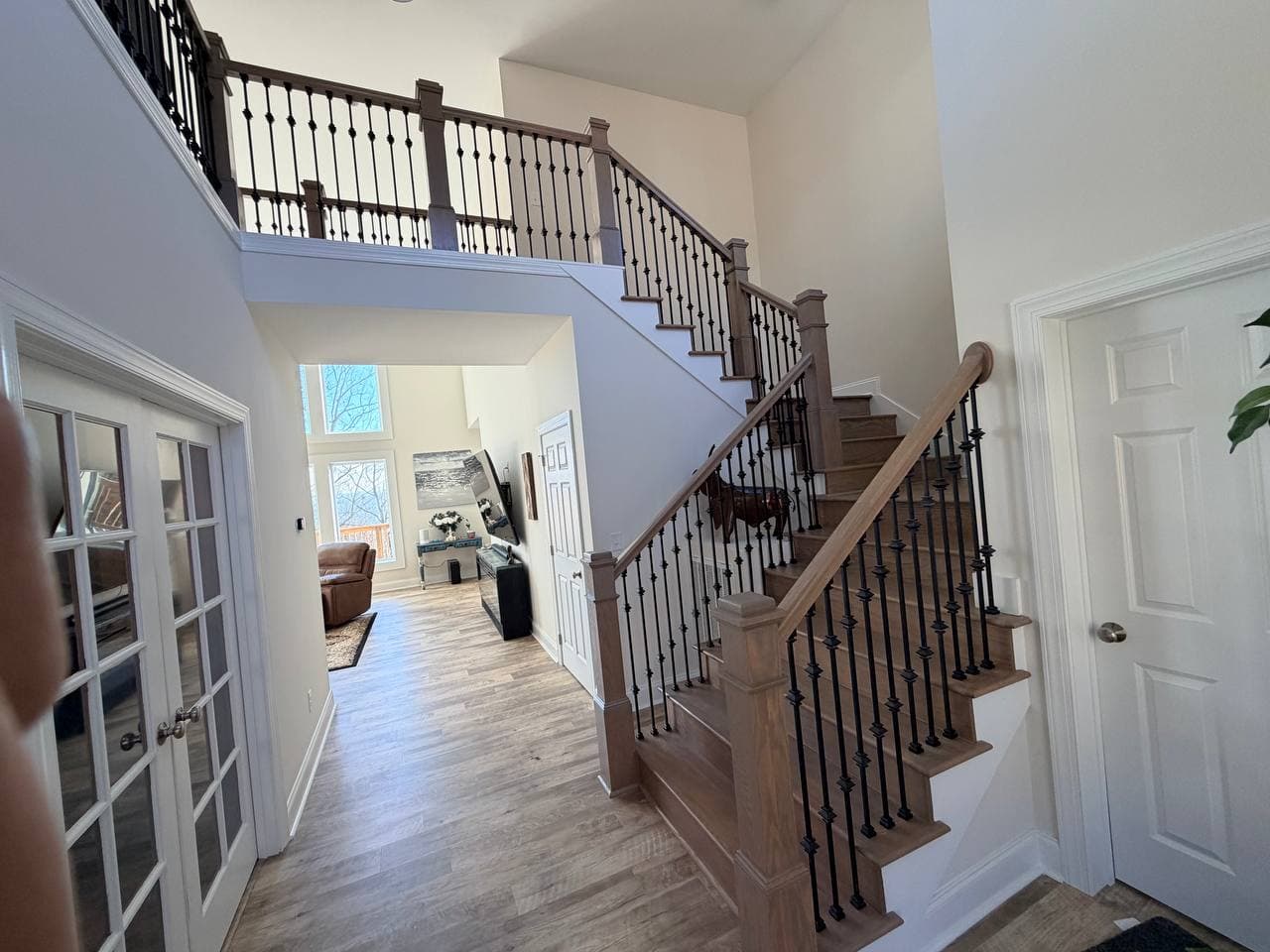 Two-story Knoxville foyer with custom oak staircase and black iron balusters by Rahimi Custom Construction